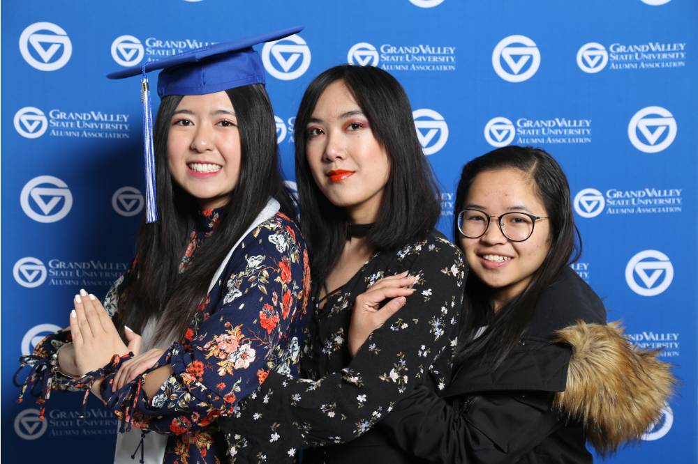 Three students pose for a photo at GradFest